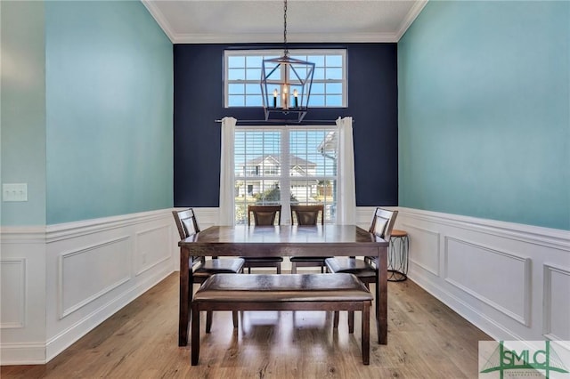 dining room with crown molding, a notable chandelier, and hardwood / wood-style flooring