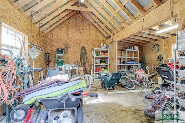 miscellaneous room featuring high vaulted ceiling and wood walls