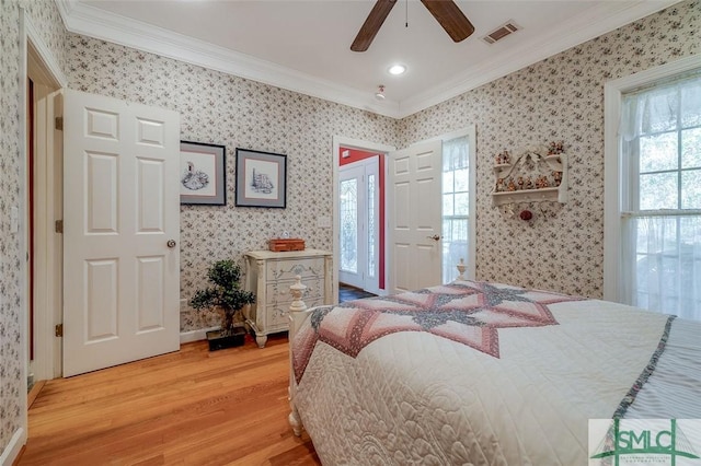 bedroom with crown molding, hardwood / wood-style floors, and ceiling fan