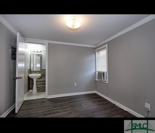 unfurnished bedroom with crown molding, connected bathroom, dark hardwood / wood-style flooring, and cooling unit