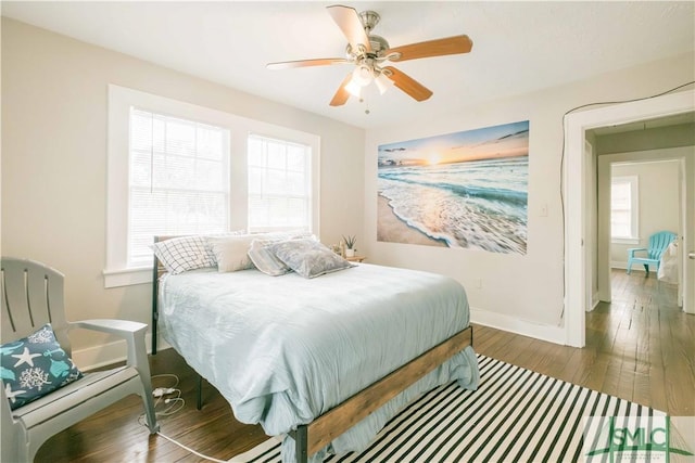 bedroom with dark wood-type flooring, ceiling fan, and multiple windows