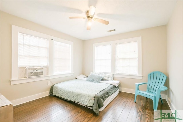 bedroom with dark wood-type flooring, ceiling fan, and cooling unit