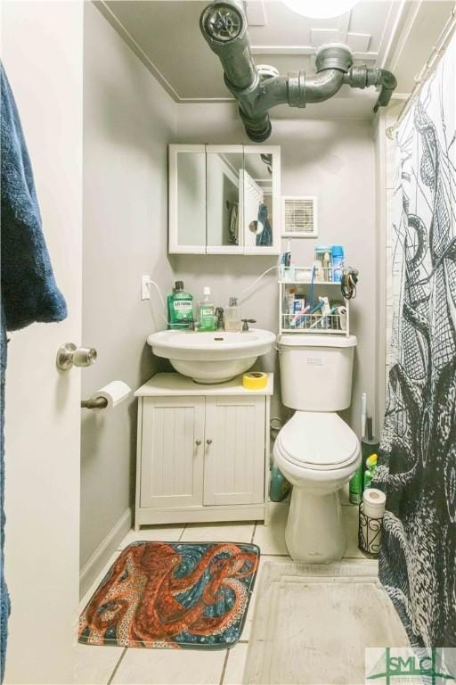 bathroom featuring vanity, tile patterned floors, and toilet