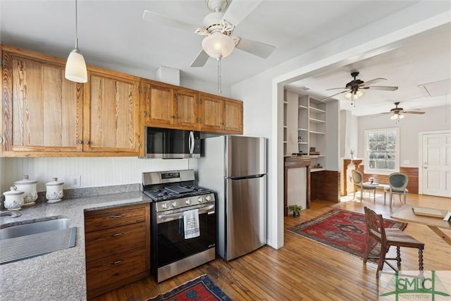 kitchen featuring sink, decorative light fixtures, dark hardwood / wood-style floors, ceiling fan, and stainless steel appliances