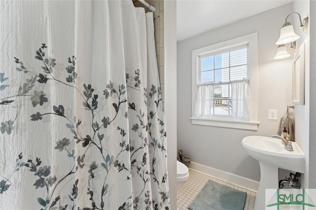 bathroom with curtained shower, tile patterned floors, and toilet