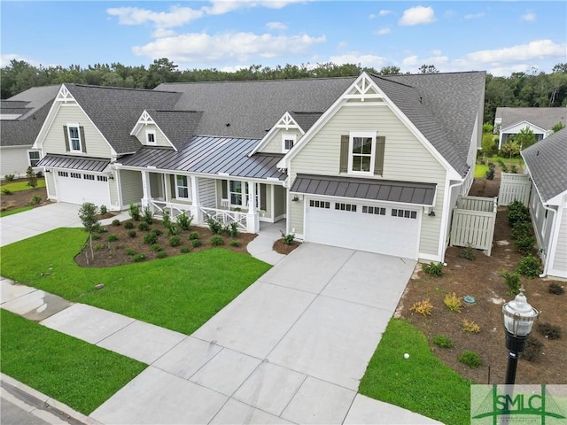 view of front of home featuring a garage, a front lawn, and covered porch