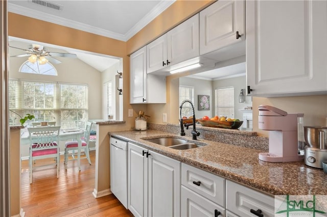 kitchen featuring crown molding, visible vents, white cabinets, a sink, and white dishwasher