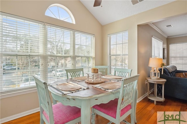 dining room featuring lofted ceiling, visible vents, ceiling fan, wood finished floors, and baseboards