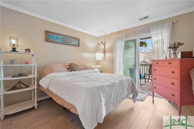 bedroom with ornamental molding, a textured ceiling, light hardwood / wood-style flooring, and access to outside