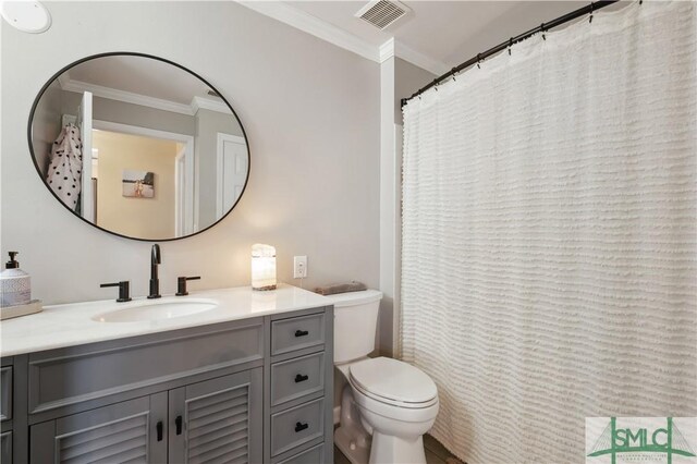 bathroom featuring vanity, ornamental molding, and toilet