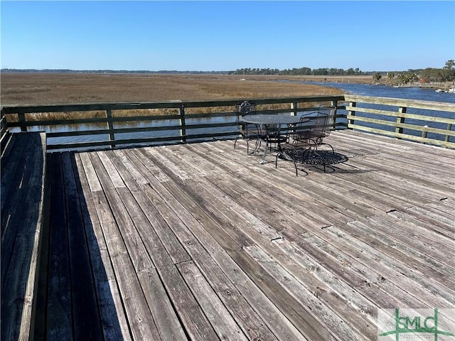 wooden deck with a water view and a rural view