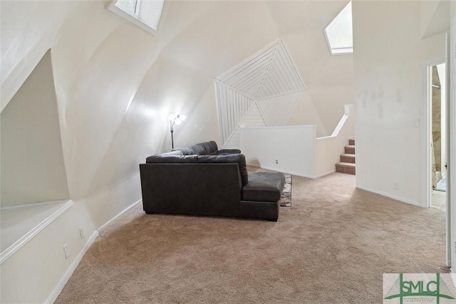 sitting room featuring light carpet, a skylight, and a high ceiling