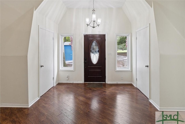 entryway featuring vaulted ceiling, a notable chandelier, and dark hardwood / wood-style flooring