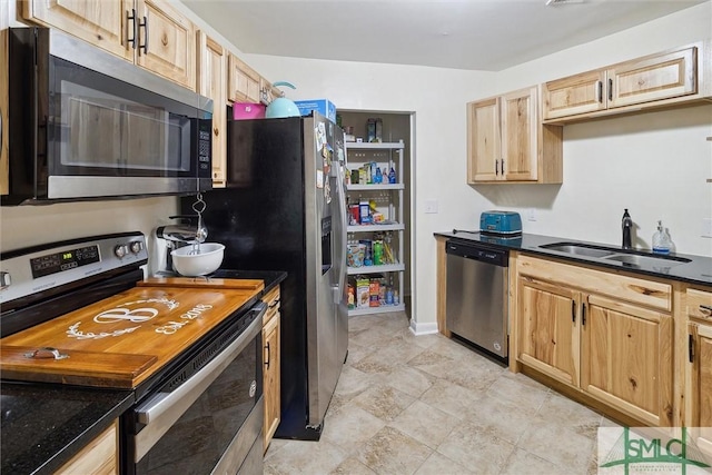 kitchen featuring light brown cabinetry, sink, and appliances with stainless steel finishes