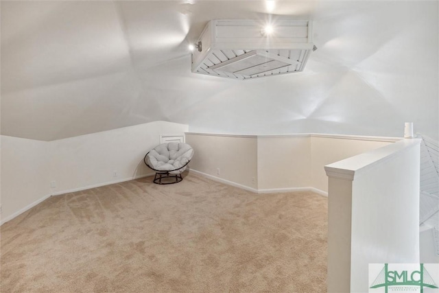 additional living space featuring vaulted ceiling and light carpet