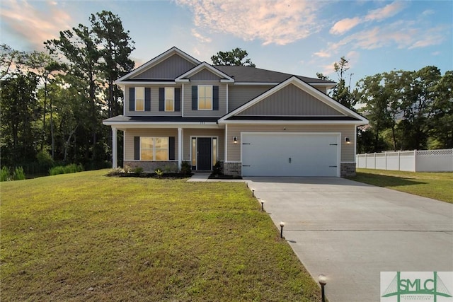 craftsman inspired home featuring a garage and a front lawn