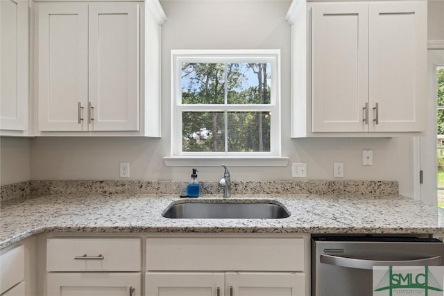 kitchen featuring light stone counters, dishwasher, sink, and white cabinets