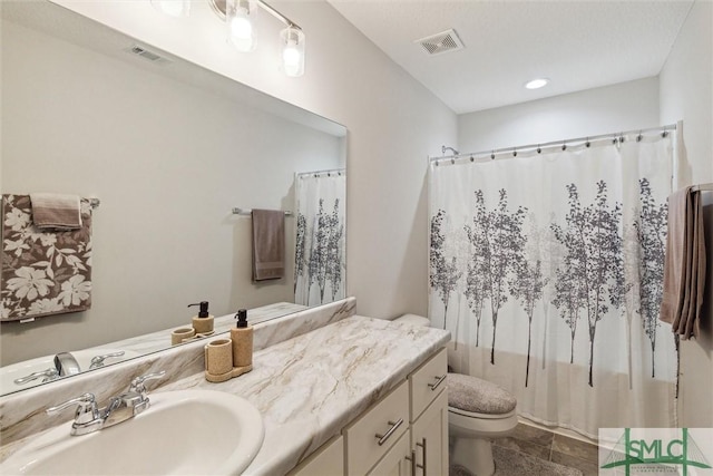 bathroom featuring vanity, curtained shower, and toilet