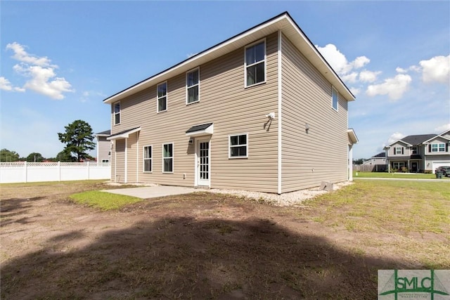 back of house with a patio area and a lawn