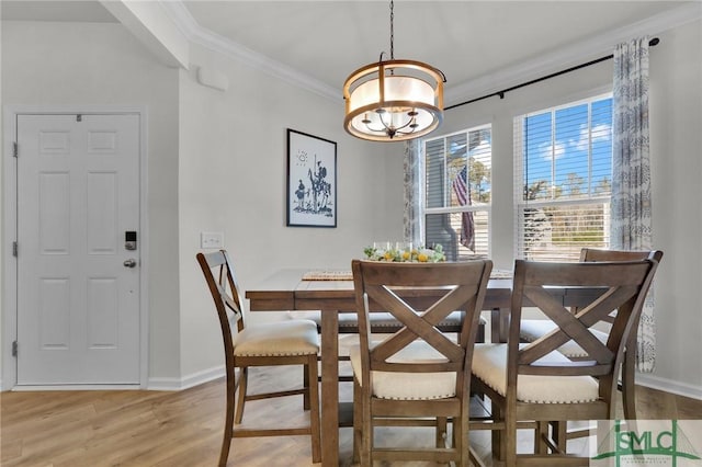 dining area featuring an inviting chandelier, ornamental molding, and light wood-type flooring