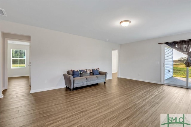 living area with hardwood / wood-style floors and a healthy amount of sunlight