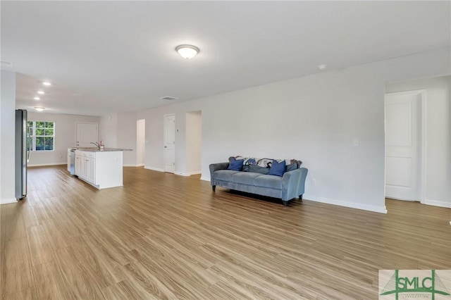 living room with sink and light hardwood / wood-style flooring