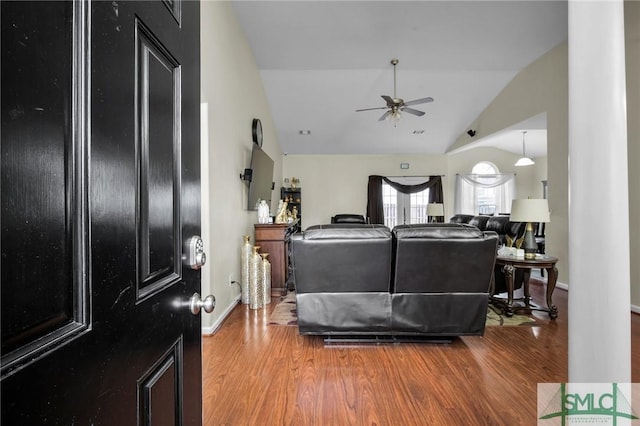 living room featuring wood-type flooring, lofted ceiling, and ceiling fan