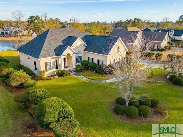 view of front of home with a water view and a front lawn