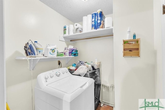 washroom featuring washer and dryer and a textured ceiling