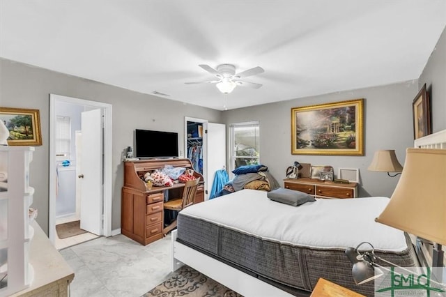 bedroom with ceiling fan, ensuite bath, a spacious closet, and a closet