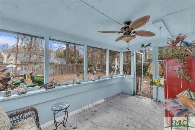 unfurnished sunroom with ceiling fan