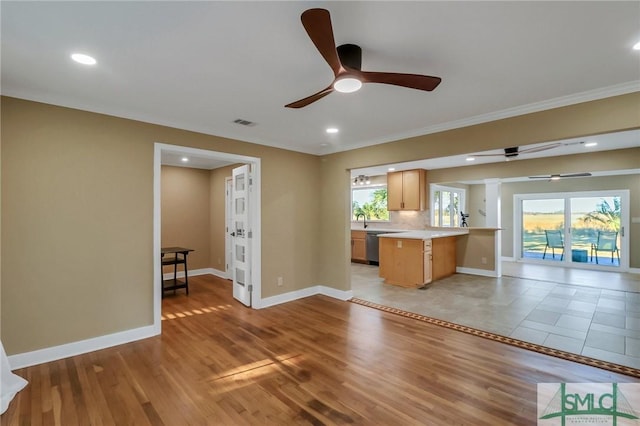 kitchen featuring ceiling fan, a healthy amount of sunlight, kitchen peninsula, and light hardwood / wood-style flooring