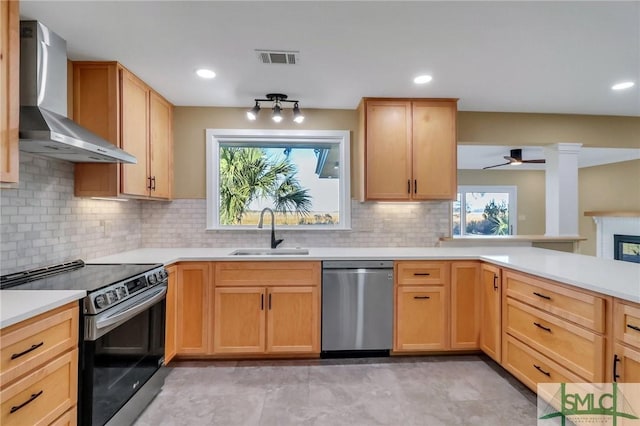 kitchen with stainless steel appliances, sink, backsplash, and wall chimney exhaust hood