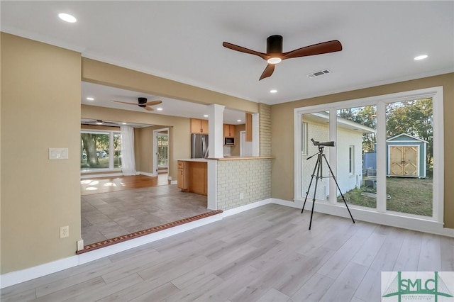 unfurnished living room with ceiling fan and light hardwood / wood-style flooring