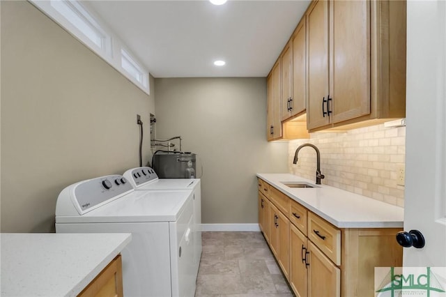 washroom featuring sink, electric water heater, and independent washer and dryer