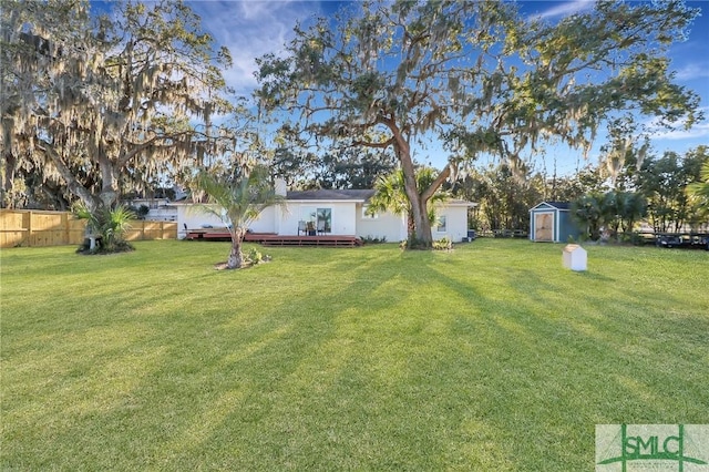 view of yard with a deck and a storage shed