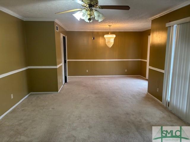 carpeted spare room featuring ceiling fan, crown molding, and a textured ceiling