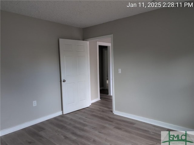 empty room featuring hardwood / wood-style floors and a textured ceiling