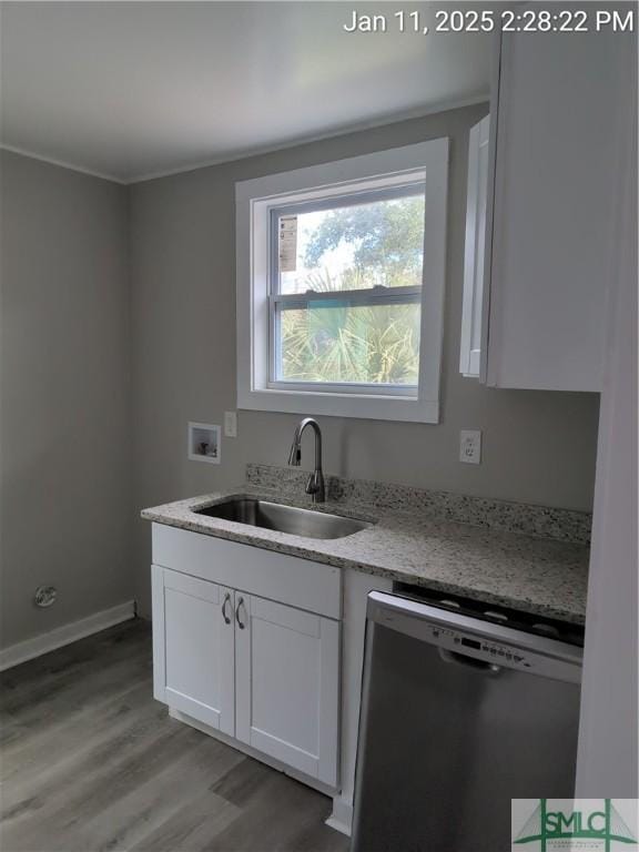 kitchen with white cabinetry, dishwasher, light stone countertops, and sink