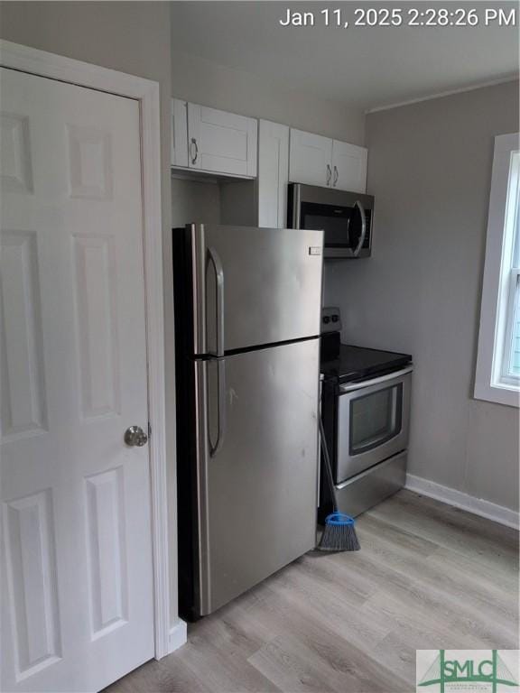 kitchen featuring white cabinetry, stainless steel appliances, and light wood-type flooring