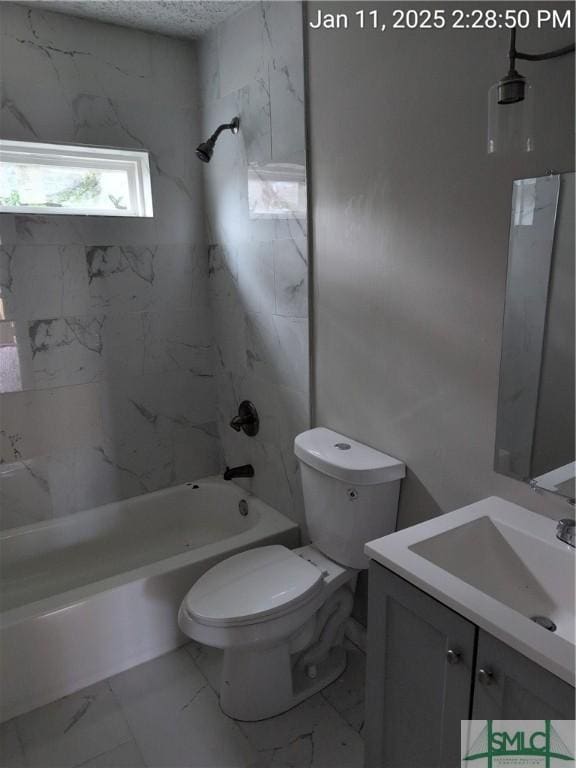 full bathroom featuring tiled shower / bath, vanity, and toilet