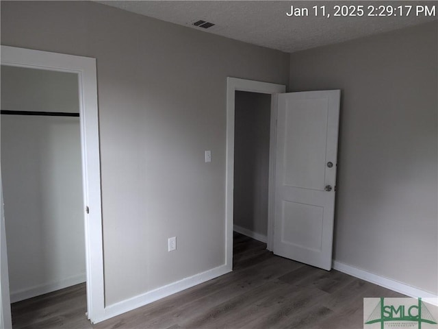 unfurnished bedroom with hardwood / wood-style flooring and a closet