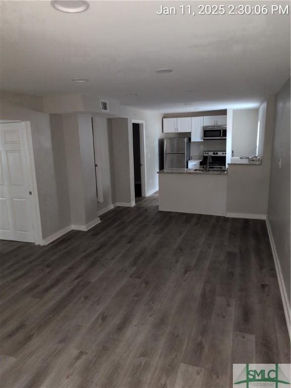 unfurnished living room with dark wood-type flooring