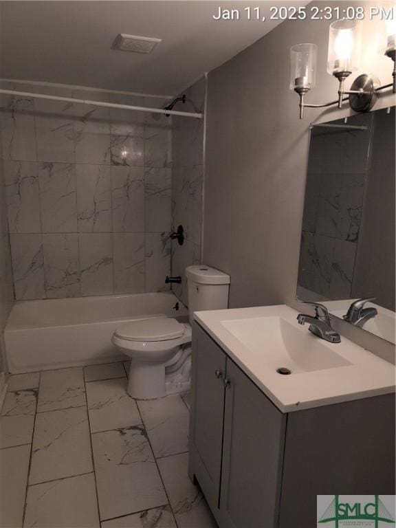 full bathroom with vanity, tiled shower / bath combo, and toilet