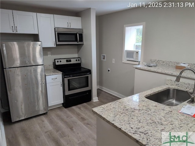 kitchen with white cabinetry, appliances with stainless steel finishes, sink, and light stone counters