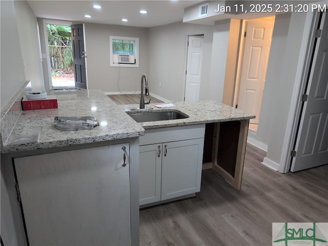 kitchen featuring dark wood-type flooring, sink, cooling unit, light stone countertops, and white cabinets