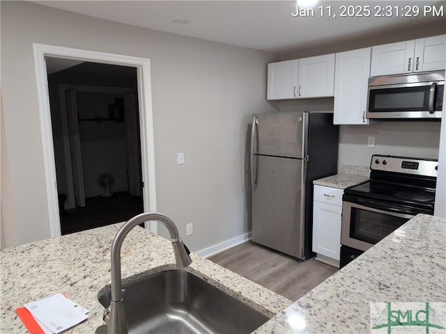 kitchen featuring white cabinetry, light stone countertops, and appliances with stainless steel finishes