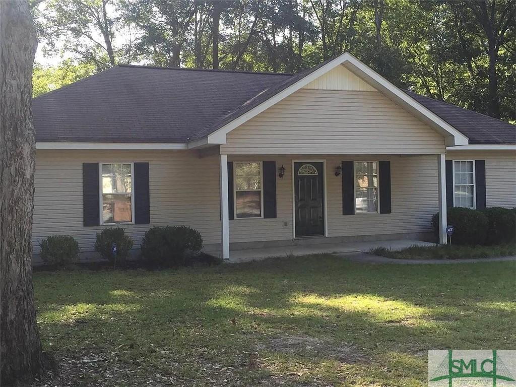 ranch-style home with a front yard and covered porch