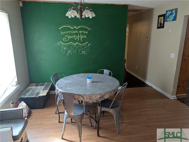 dining room featuring hardwood / wood-style flooring and an inviting chandelier