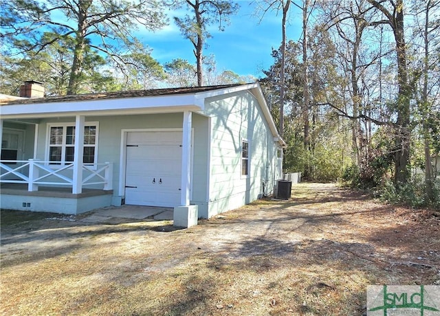 view of property exterior with a porch, central AC, a chimney, and an attached garage